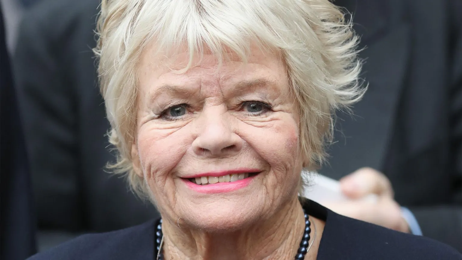 Getty Images Judith Chalmers smiling in a navy blue blazer and necklace in 2016